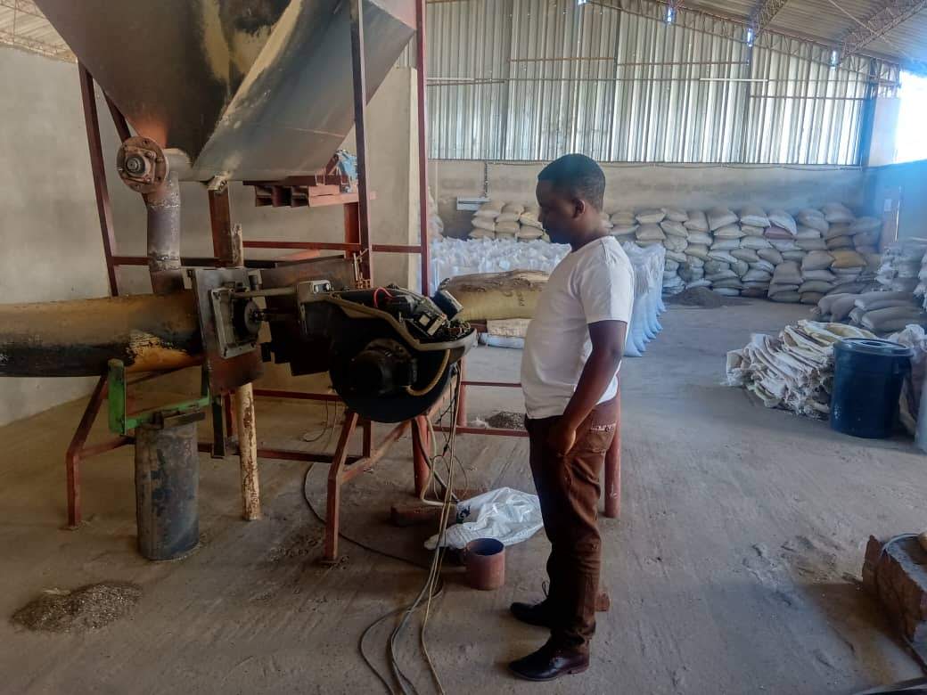 Engineer in protective clothing beside industrial processing equipment during a consultancy site visit.