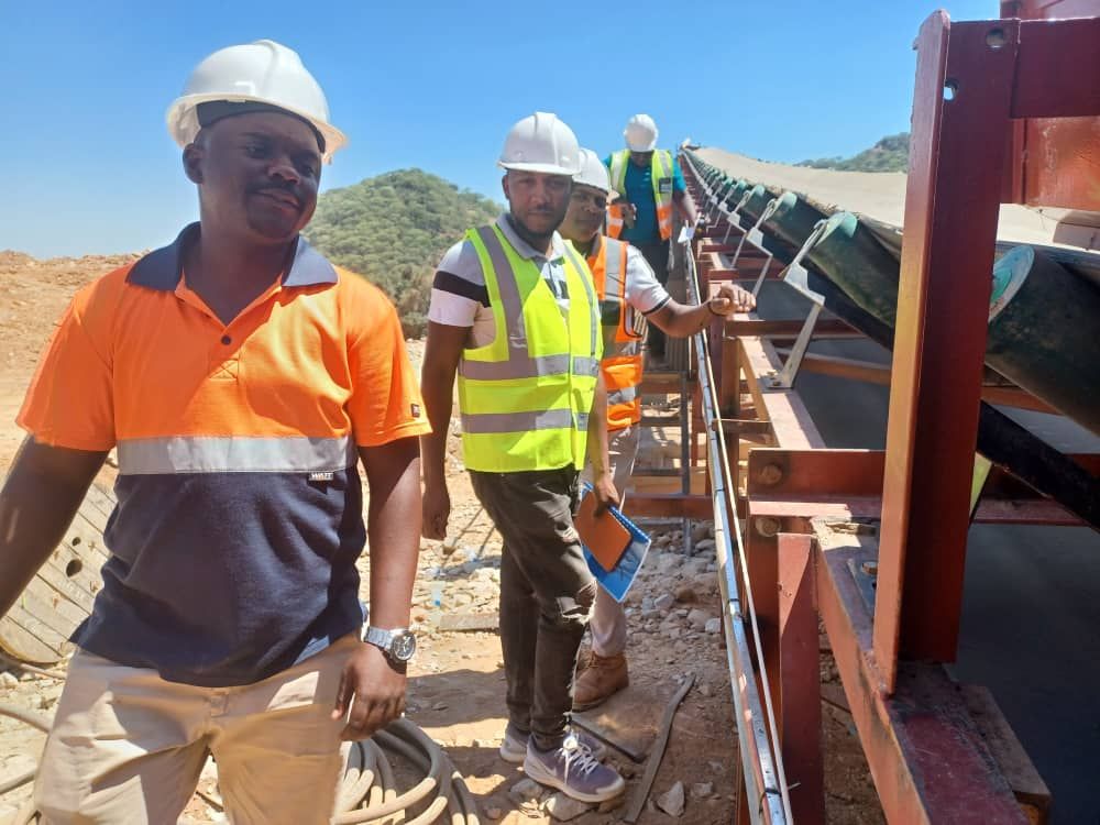 Engineering team inspecting a conveyor structure on a structural engineering project site.