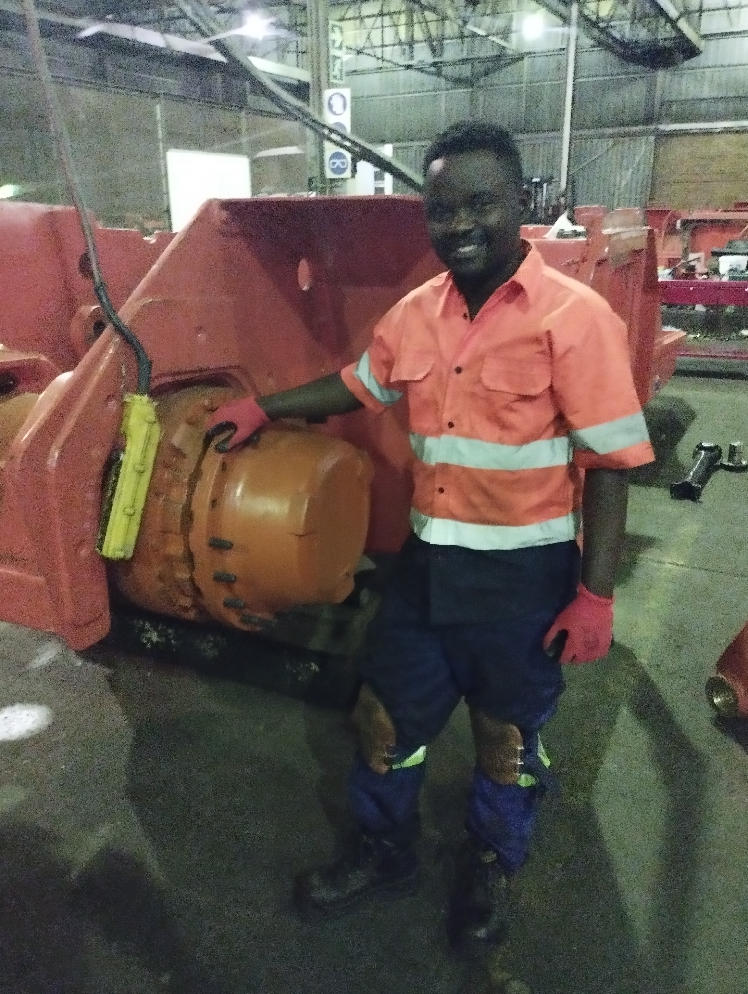 Technicians working on red industrial motor and pump equipment on-site.