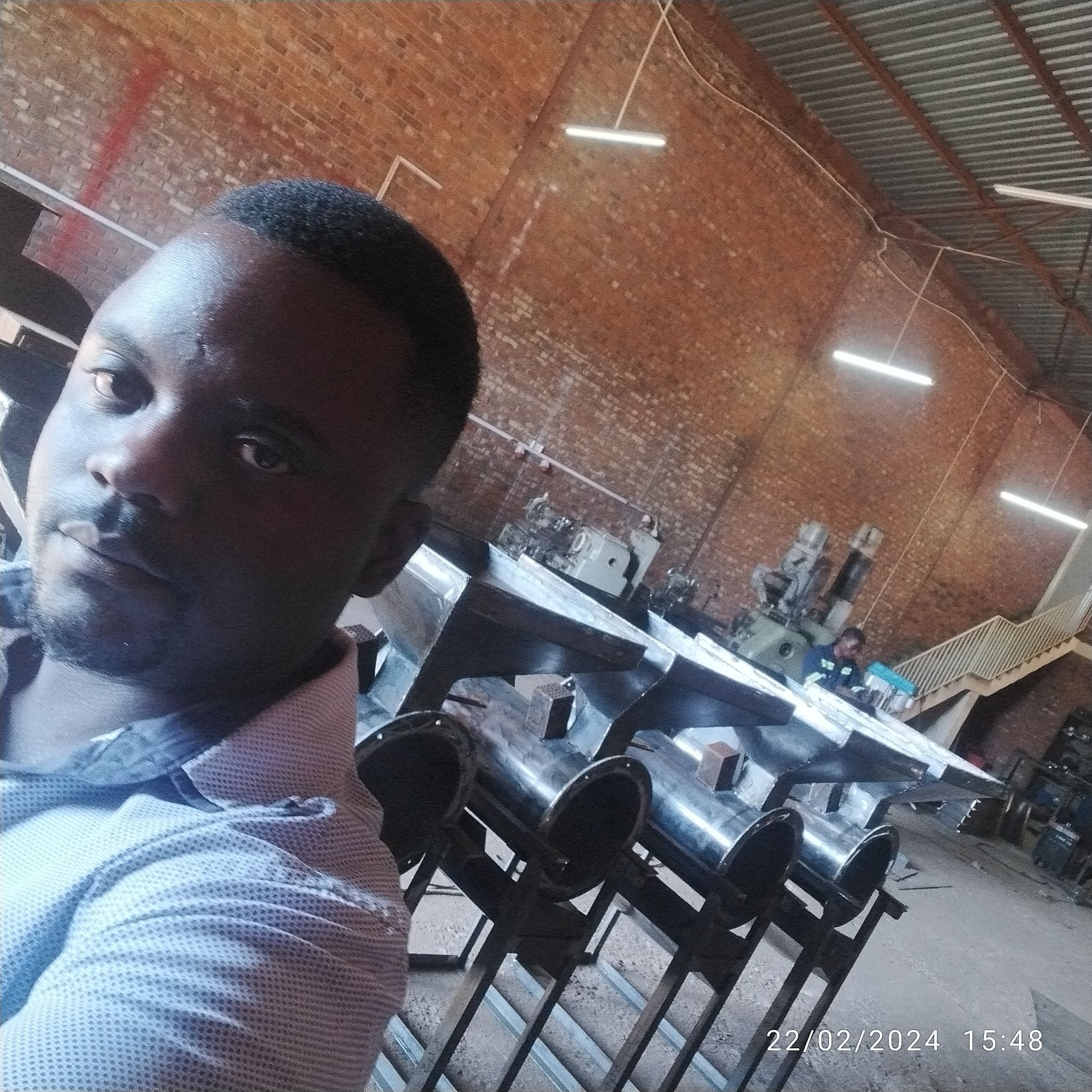 Engineer near industrial machinery and equipment on-site.