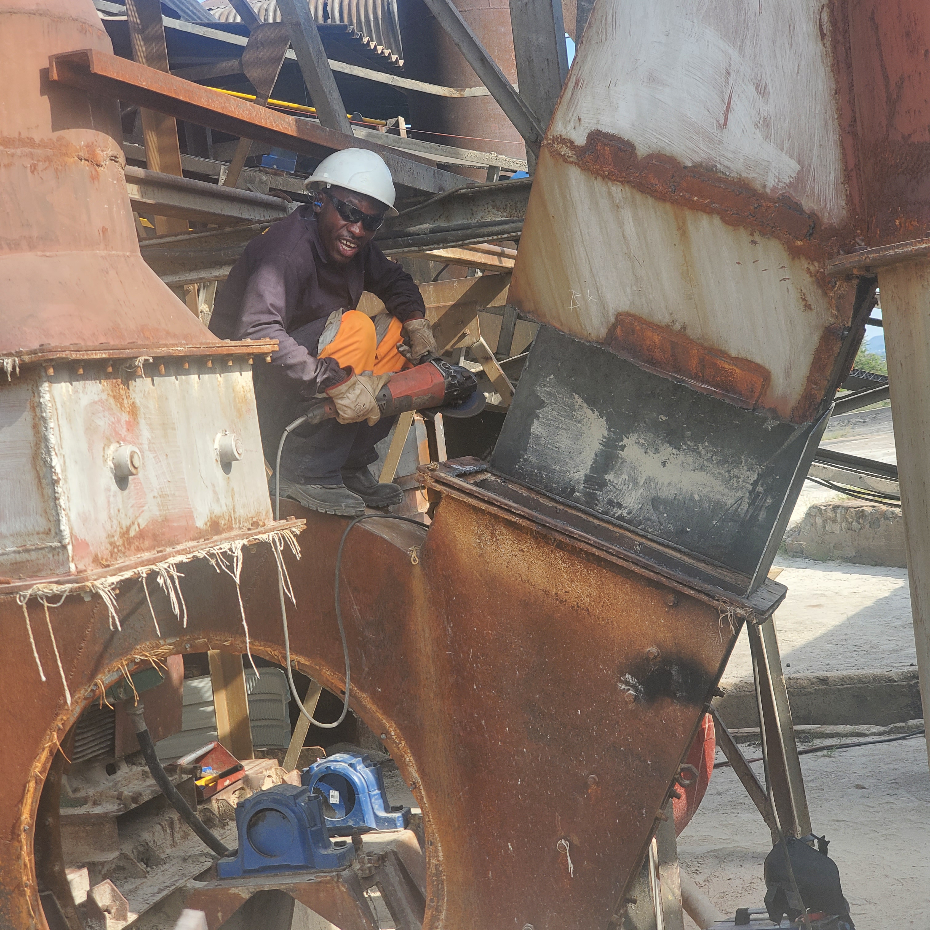 Technician working inside a rusted industrial equipment housing during a rebuild.